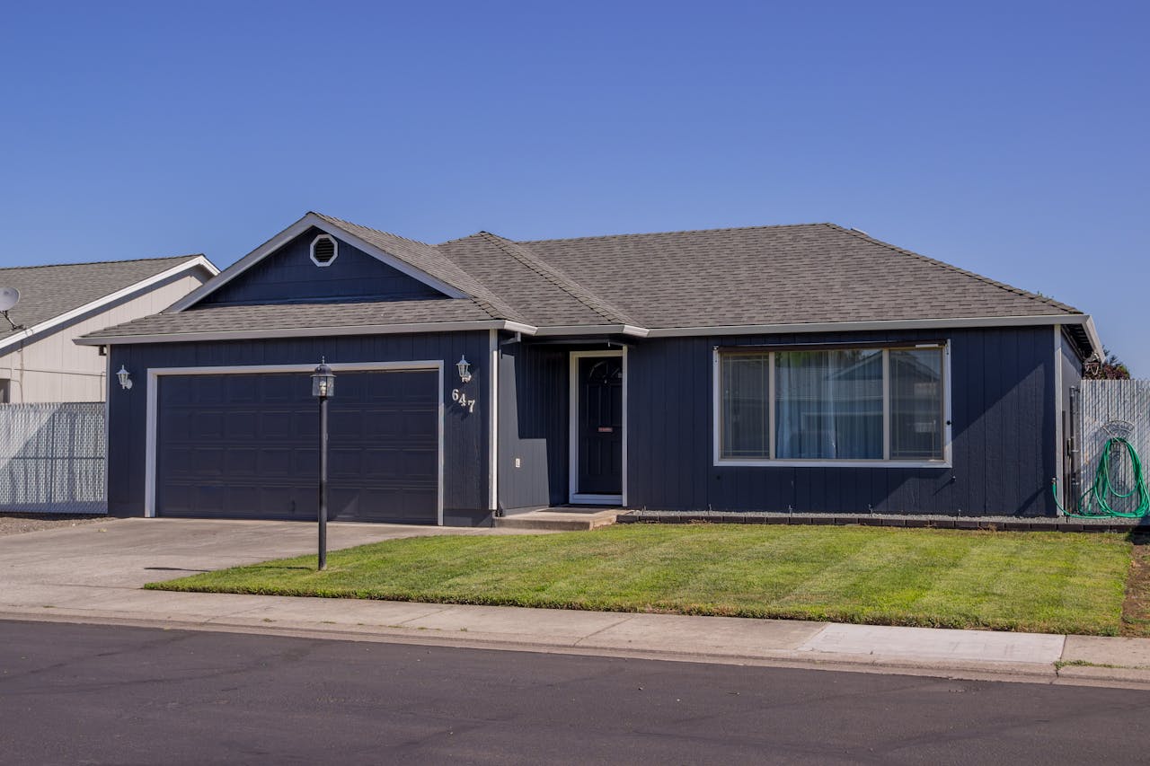 Charming suburban house with driveway, garage, and well-maintained lawn.